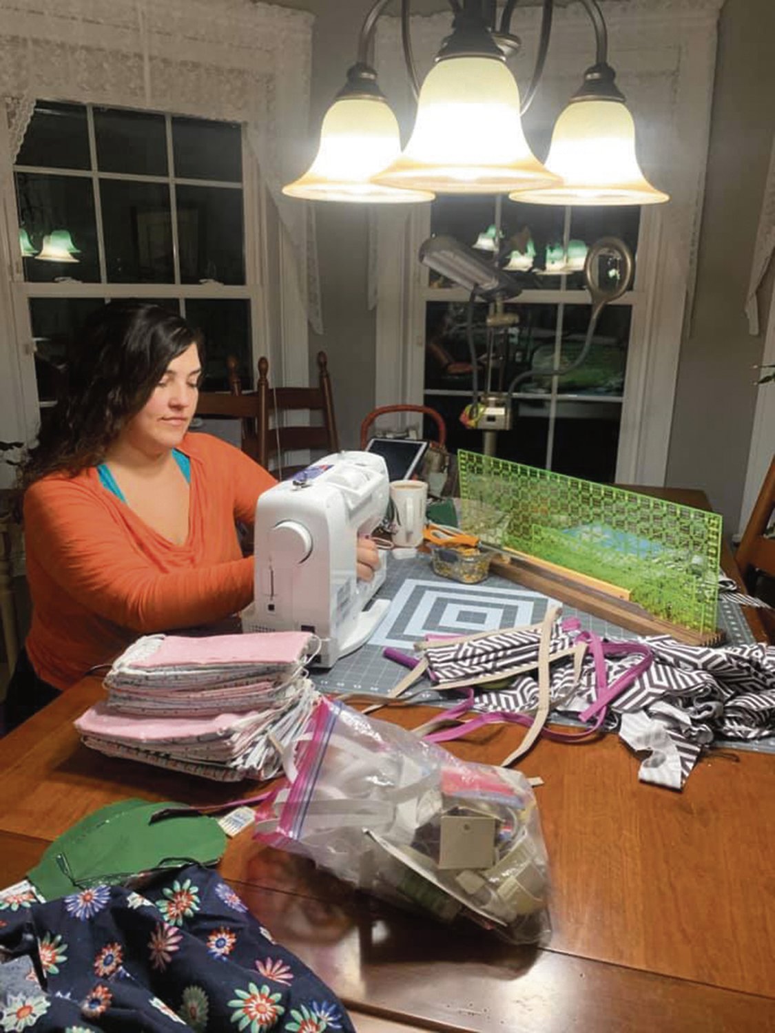 Hobart resident Melissa Haacker hard at work sewing masks while she is quarantined with her parents in Albany.